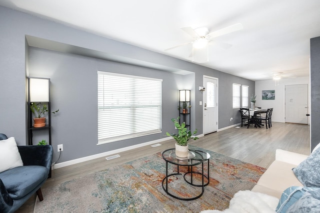 living room featuring wood-type flooring and ceiling fan