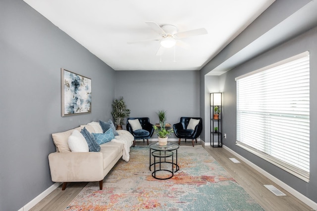 living room featuring light hardwood / wood-style flooring, a wealth of natural light, and ceiling fan