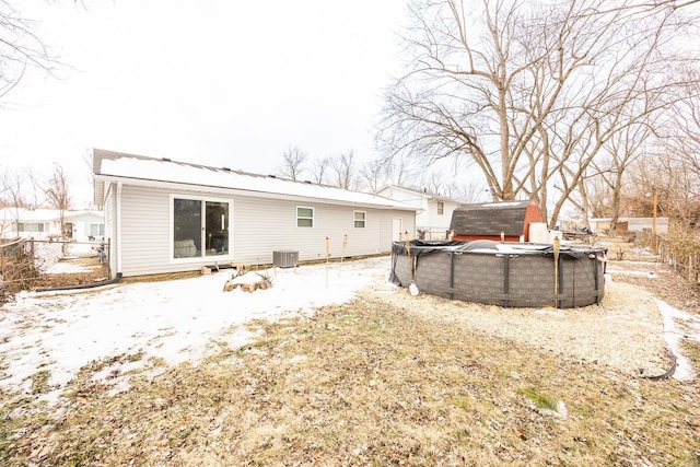 rear view of property with cooling unit and a covered pool