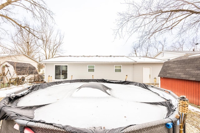 view of snow covered back of property