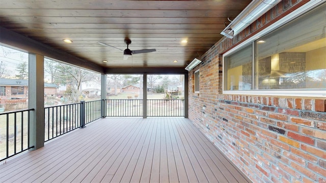 unfurnished sunroom with ceiling fan