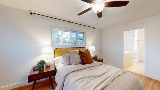 bedroom with light hardwood / wood-style flooring, ceiling fan, and ensuite bathroom