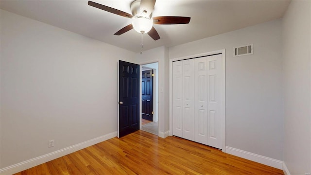 unfurnished bedroom featuring light hardwood / wood-style floors, a closet, and ceiling fan