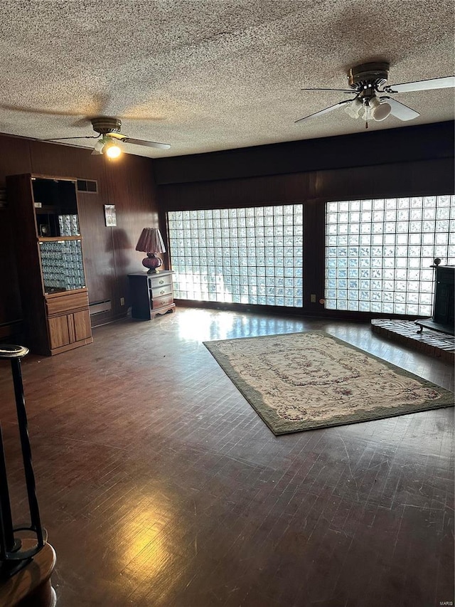 unfurnished living room featuring ceiling fan, a textured ceiling, and hardwood / wood-style floors