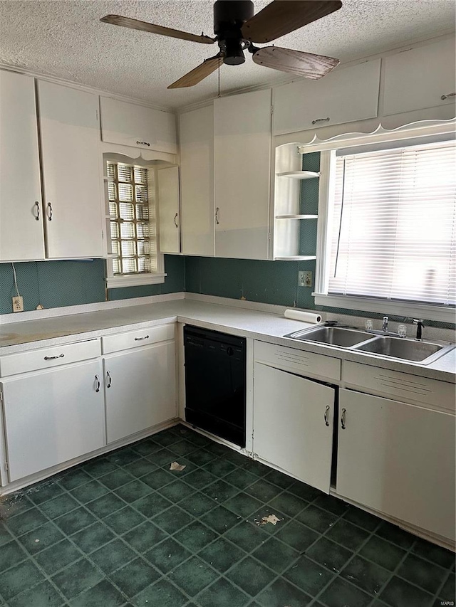 kitchen with ceiling fan, sink, black dishwasher, white cabinetry, and a textured ceiling