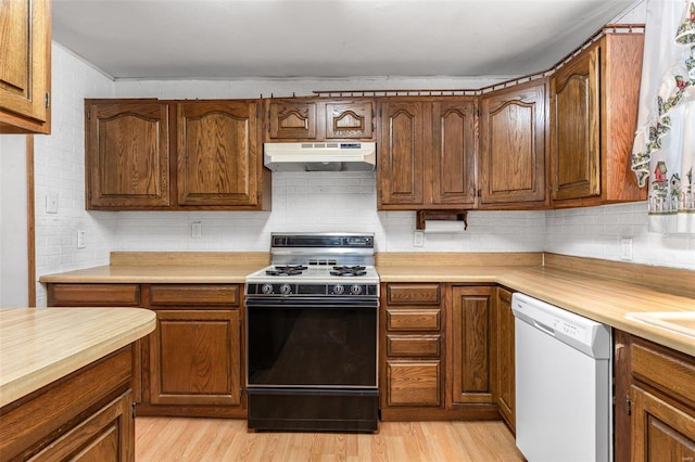 kitchen featuring light hardwood / wood-style floors, range with gas stovetop, tasteful backsplash, and dishwasher