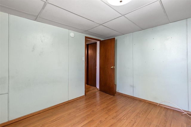 unfurnished room with light hardwood / wood-style floors and a paneled ceiling