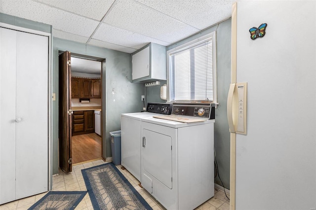 washroom with washer and dryer and cabinets