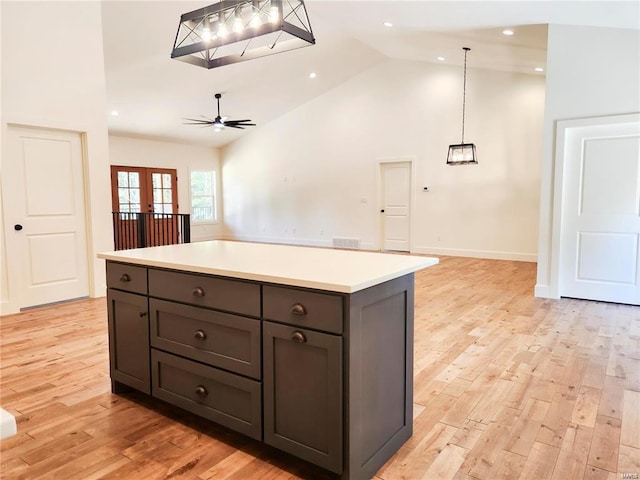 kitchen featuring light hardwood / wood-style floors, ceiling fan, french doors, high vaulted ceiling, and decorative light fixtures