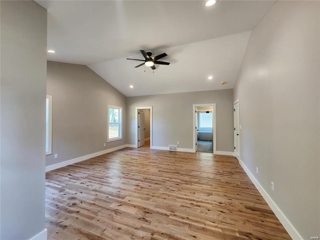 empty room featuring ceiling fan, vaulted ceiling, and light hardwood / wood-style floors