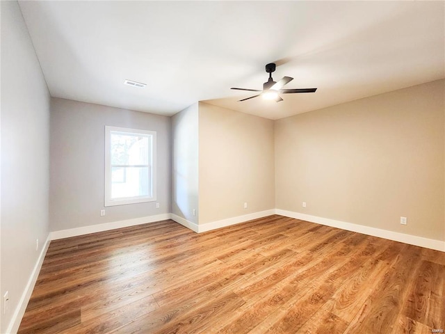 empty room with ceiling fan and light hardwood / wood-style floors