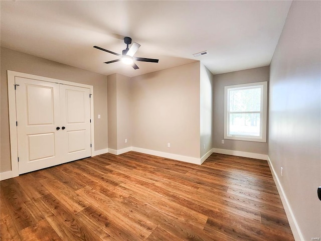 unfurnished bedroom with ceiling fan and hardwood / wood-style flooring