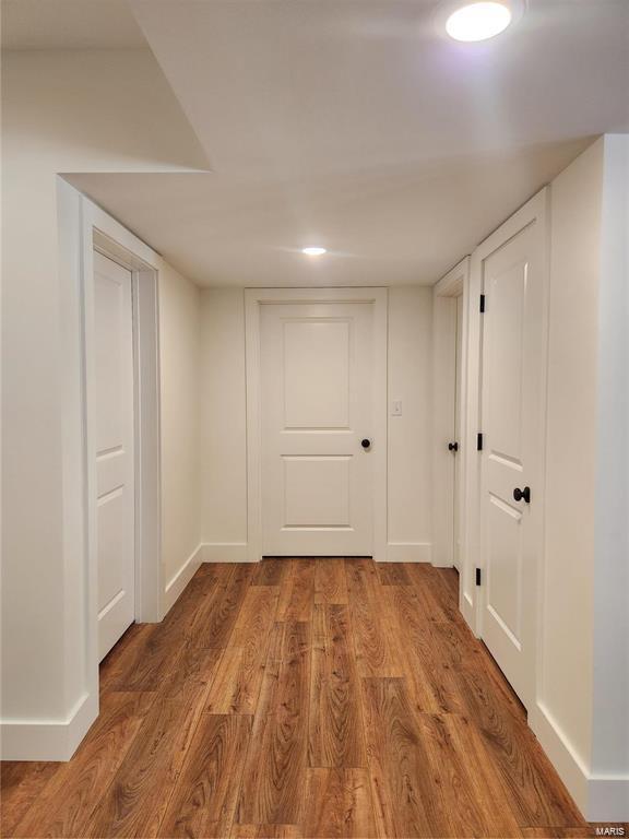 corridor with hardwood / wood-style floors