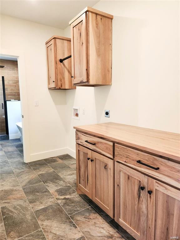 laundry room with electric dryer hookup, hookup for a washing machine, and cabinets