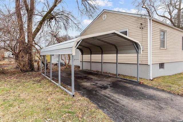 view of parking / parking lot featuring a carport and a lawn