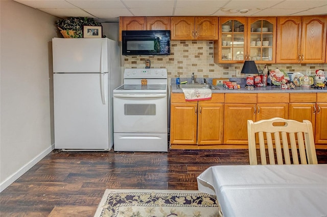 kitchen with white appliances, dark hardwood / wood-style flooring, tasteful backsplash, sink, and a drop ceiling