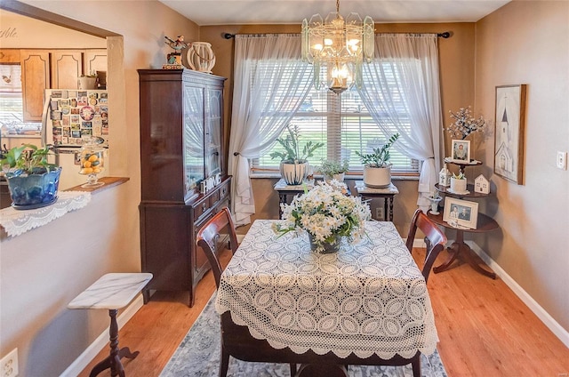 dining room with light hardwood / wood-style flooring and a notable chandelier