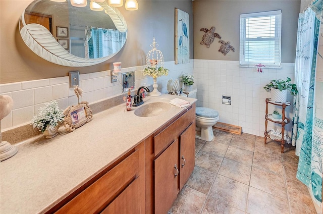 bathroom with tile patterned floors, tile walls, toilet, and vanity