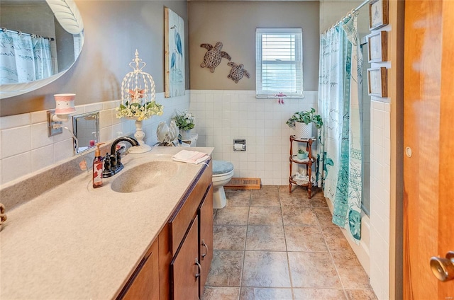 bathroom featuring curtained shower, tile patterned floors, vanity, tile walls, and toilet