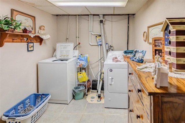 clothes washing area featuring light tile patterned floors and washer and clothes dryer