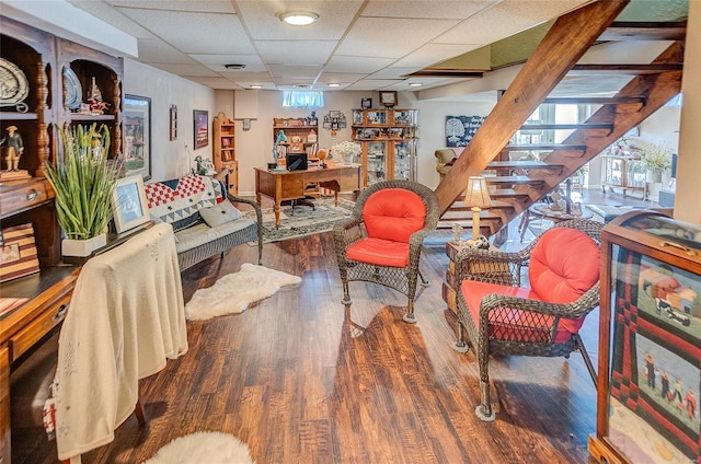 interior space with plenty of natural light, hardwood / wood-style floors, and a drop ceiling