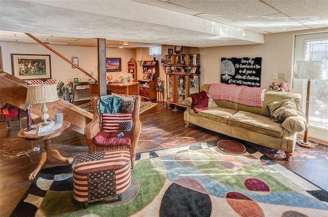 living room featuring a drop ceiling and dark hardwood / wood-style floors