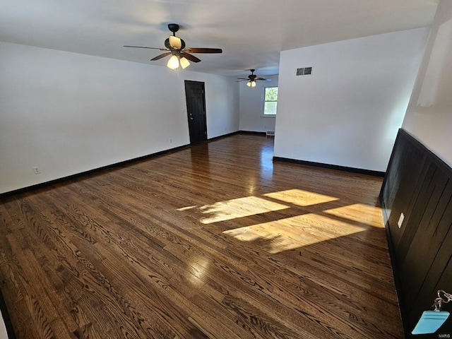 empty room with ceiling fan and dark hardwood / wood-style floors