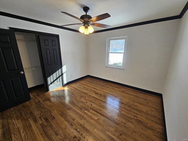 unfurnished bedroom with a closet, ceiling fan, ornamental molding, and dark wood-type flooring