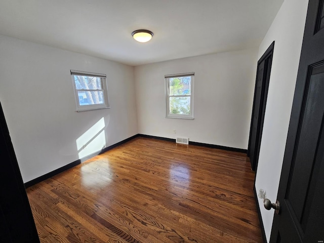 unfurnished room featuring dark hardwood / wood-style flooring