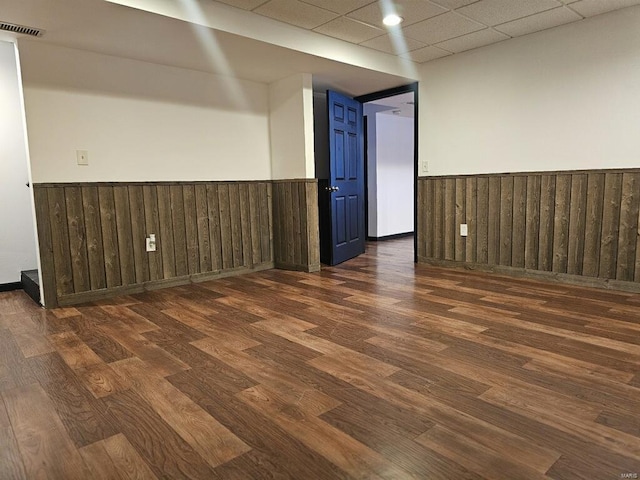 unfurnished room featuring a paneled ceiling and dark wood-type flooring