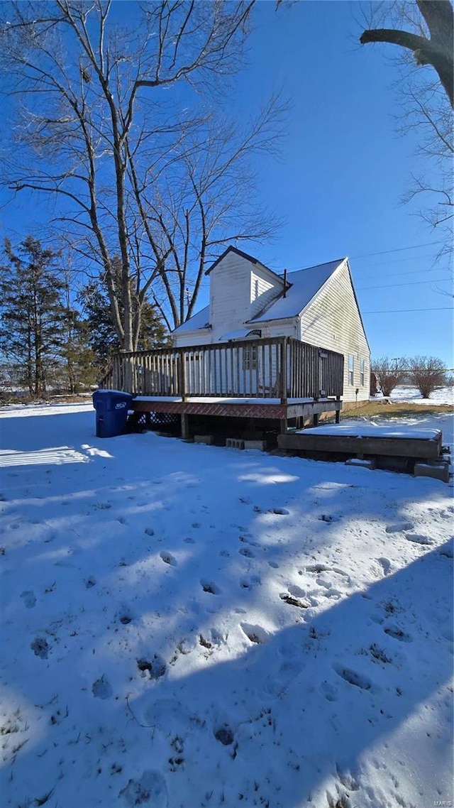 snow covered house with a deck