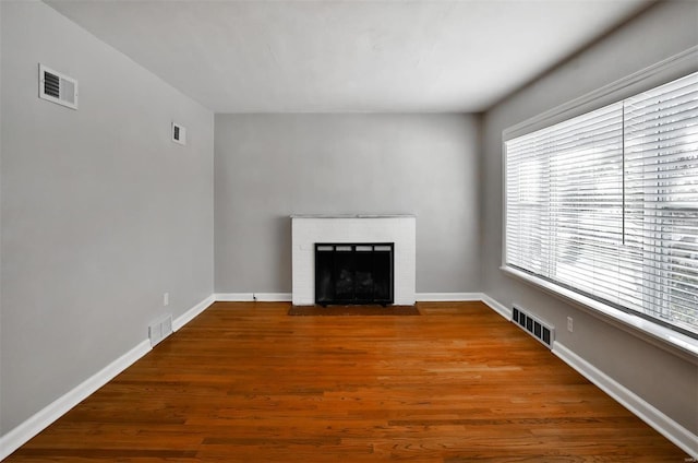 unfurnished living room featuring a fireplace and hardwood / wood-style flooring