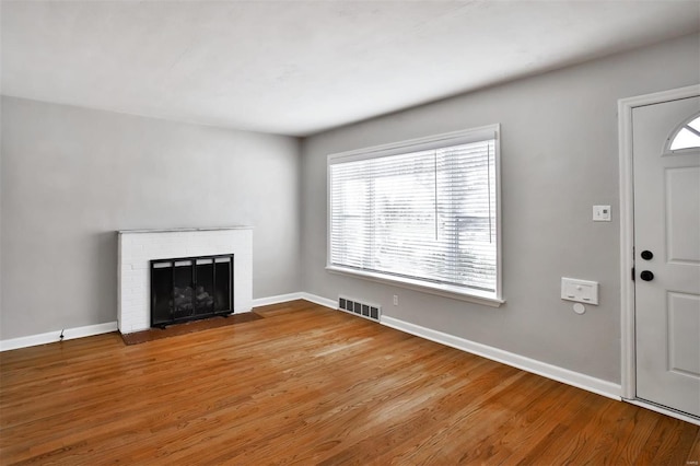 unfurnished living room featuring a fireplace and hardwood / wood-style floors