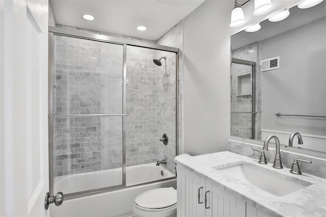 full bathroom featuring shower / bath combination with glass door, vanity, and toilet