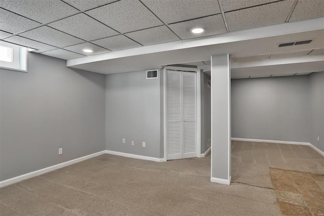 basement featuring carpet floors and a drop ceiling