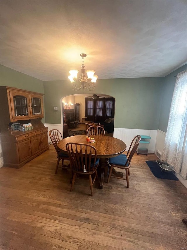 dining area featuring wood-type flooring and a notable chandelier