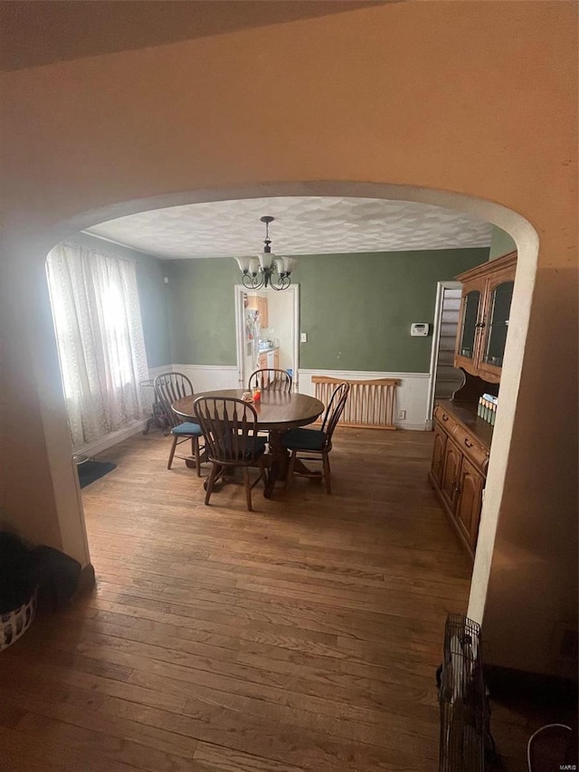 dining room with radiator, dark wood-type flooring, and a notable chandelier