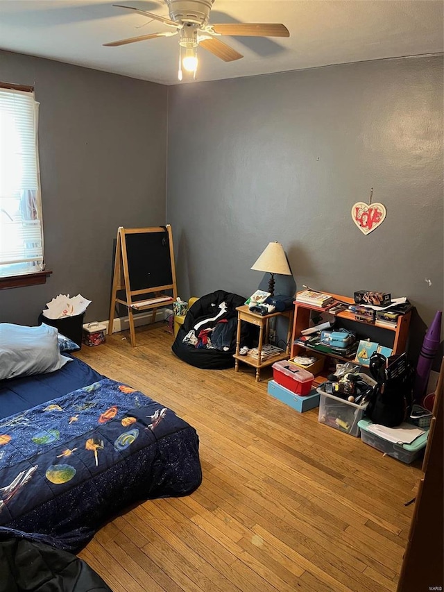 bedroom with ceiling fan and hardwood / wood-style flooring