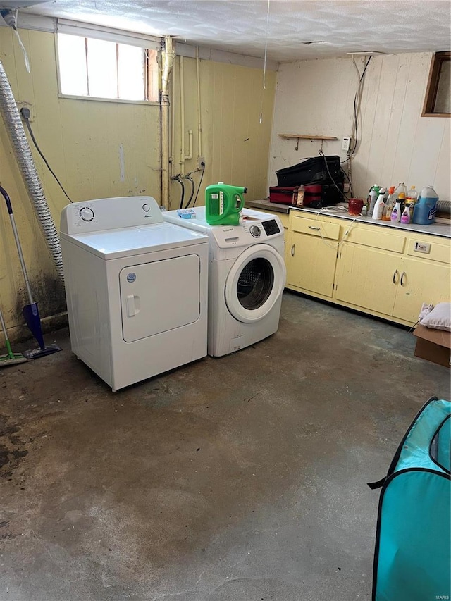 laundry room featuring cabinets and washer and clothes dryer