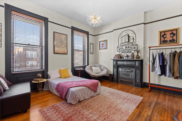 bedroom featuring an inviting chandelier and hardwood / wood-style floors