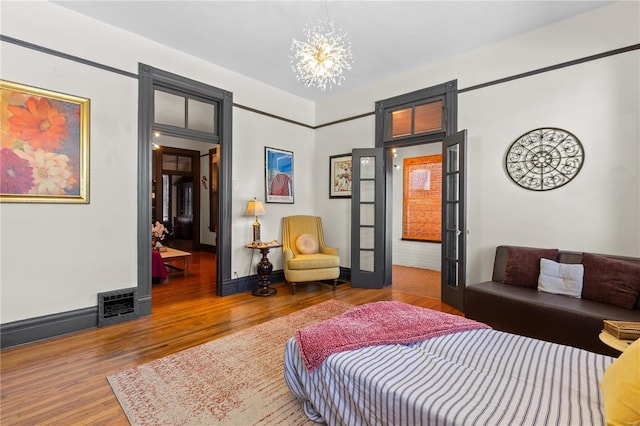 bedroom featuring hardwood / wood-style flooring and a notable chandelier