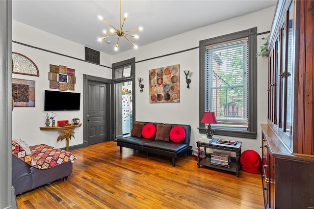 living room featuring an inviting chandelier and wood-type flooring