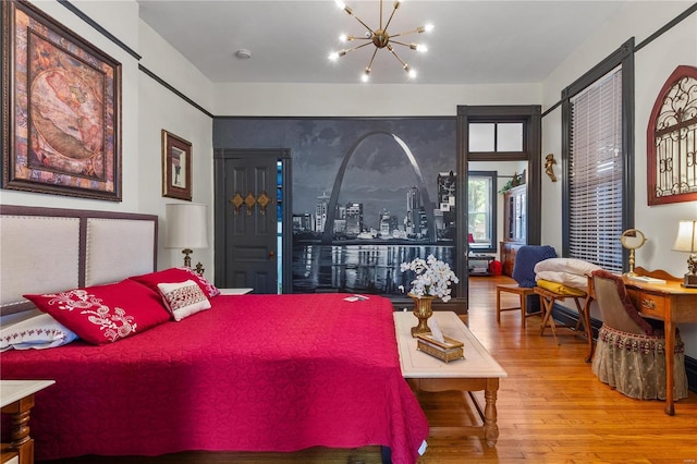 bedroom featuring wood-type flooring and a chandelier