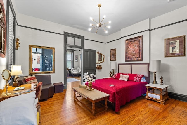 bedroom featuring an inviting chandelier and hardwood / wood-style floors