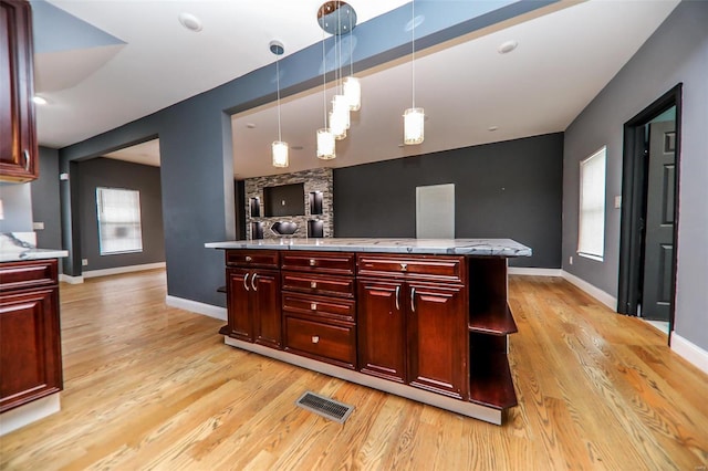 kitchen with light hardwood / wood-style flooring and pendant lighting