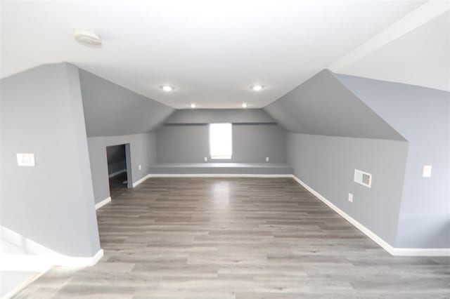 bonus room with lofted ceiling and light wood-type flooring