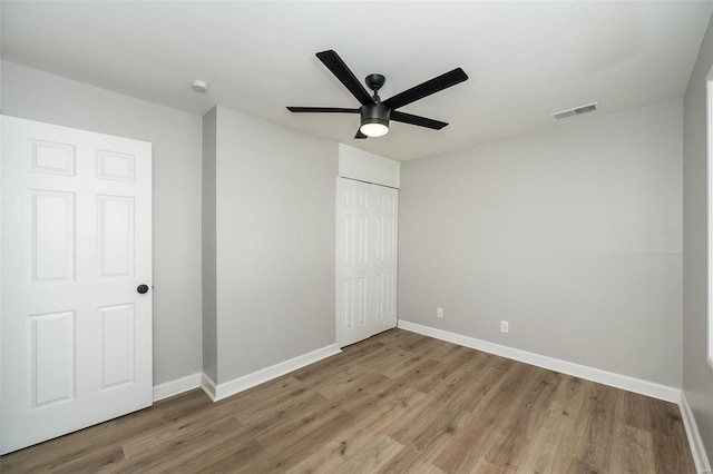 unfurnished bedroom with ceiling fan, light hardwood / wood-style flooring, and a closet