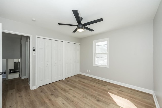 unfurnished bedroom with two closets, ceiling fan, and light hardwood / wood-style flooring