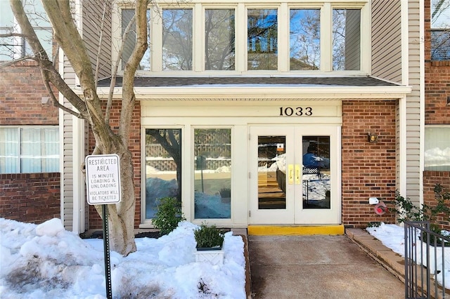 snow covered property entrance with french doors