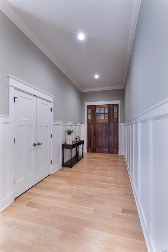 entrance foyer featuring crown molding and light hardwood / wood-style flooring